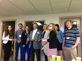 Warden Jim Ginn (centre), cuts the ribbon to officially open the new Gateway office in Goderich. He is accompanied by the six students who will conduct research projects, a representative from Libro and Gateway President, Dr. Agnes Kluz.