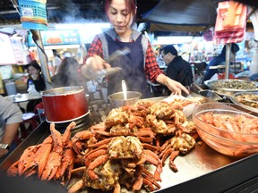 In this photo taken on April 13, 2015, a local chef prepares food at the Raohe night market in Taipei. Pungent slices of fermented tofu, piping hot pork buns and crisp green guava slices are some of Taiwan's classic street eats, with the best stalls attracting queues of locals and visitors. (SAM YEH/AFP/Getty Images)