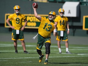 Quarterback Mike Reilly unloads a pass as Danny O'Brien and Brett Smith look on. The Edmonton Eskimos practiced at Commonwealth Stadium on May 30, 2017 to prepare for their first pre-season game on June 11.