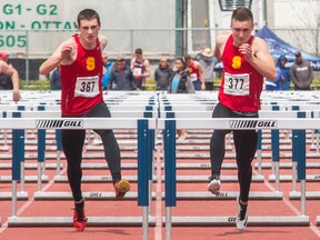 Liam Sands of the Sydenham Golden Eagles, left, seen here running in almost mirror-image fashion with teammate Merik Wilcock in the 110-metre hurdles final Kingston Area Secondary Schools Athletic Association track and field meet on May 11, qualified for the Ontario Federation of School Athletic Associations meet to be held Thursday to Sunday in Belleville. Wilcock won the KASSAA final, with Sands finishing a close second. Sands, however, finished third in the final at the East Regionals last week to qualify for OFSAA, with Wilcock placing 11th in the preliminaries and not making the final. (Tim Gordanier/The Whig-Standard)