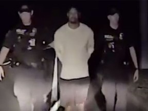 Tiger Woods is walked to a police car in handcuffs after failing a sobriety test (Screen grab)