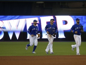 Blue Jays outfielders run back to their teammates after the team beat the Cincinnati Reds 5-4 on May 31, 2017 to sweep the three-game series. (JACK BOLAND/Toronto Sun)