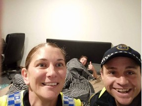 Tasmanian Police officers Natalie Siggins and Jeremy Blyth took a selfie with a dazed Reece Park in the background. The photo has since gone viral. (Facebook/Tasmania Police)