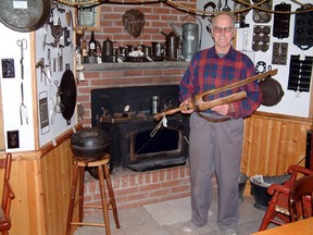 Harvey Waud holds a wooden peg leg, an important piece of his collection, while surrounded by other antiques in his collection in this family photo. (Submitted)