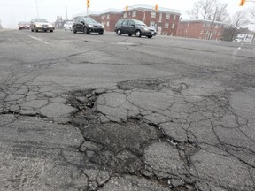 Traffic flows along Carling Avenue, past the cracks in the road surface.