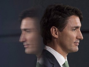 Prime Minister Justin Trudeau is reflected in a television as he listens to a question during a news conference in Ottawa, Wednesday September 21, 2016. Trudeau will help TV morning show hosts Kelly Ripa and Ryan Seacrest kick off their visit to Canada on Monday. (THE CANADIAN PRESS/Adrian Wyld)