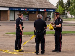 Police take down tape at the scene after a shooting at a strip mall located at Hermitage Road and 40th Street on Thursday June 1, 2017, in Edmonton.