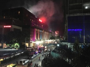 Smoke rises from the Resorts World Manila complex early Friday, June 2, 2017 in Manila, Philippines. Gunshots and explosions rang out early Friday at a mall, casino and hotel complex near Manila's international airport in the Philippine capital, sparking a security alarm amid an ongoing Muslim militant siege in the country's south. (AP Photo/Bullit Marquez)