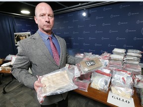 Acting Insp. Steve Watts holds seized fentanyl and cocaine at Toronto Police HQ on Thursday, June 1, 2017. Police seized drugs, weapons and money as part of four different operations. (MICHAEL PEAKE/TORONTO SUN)