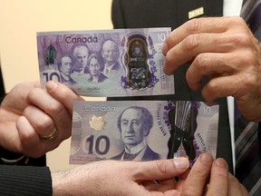 Kingston Mayor Bryan Paterson, left, exchanges his regular $10 bill for a new commemorative one on Thursday with Manuel Parriera of the Bank of Canada after the launch of a commemorative $10 banknote at Bellevue House, once the home of Canada’s first prime minister, Sir John A. Macdonald. (Ian MacAlpine/The Whig-Standard)