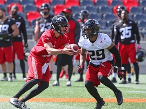 Trevor Harris hands off the ball to William Powell of the Ottawa Redblacks at TD Place in Ottawa during training camp on June 1, 2017. (Jean Levac/Postmedia)