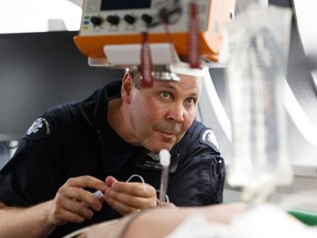 Flight paramedic Michel Lacasse runs a drill with paramedic clinical educator Chris Bassil (not shown) inside Canada's first mobile flight simulator trailer for air ambulance training during an unveiling at STARS Edmonton base at Edmonton International Airport on Thursday, June 1, 2017. Ian Kucerak / Postmedia