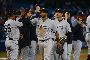 New York Yankees Aaron Hicks CF high fives first base coach Tony Pena (56) after the game . He had three doubles, four hits and six RBIs in the 12-2 drubbing of the Toronto Blue Jays  in Toronto, Ont. on Thursday June 1, 2017. Jack Boland/Toronto Sun/Postmedia Network