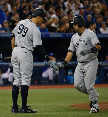 New York Yankees Gary Sanchez C (24) low fives teammate Aaron Judge (99) after stroking a solo HR in the second inning  in Toronto, Ont. on Thursday June 1, 2017. Jack Boland/Toronto Sun/Postmedia Network