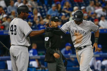 New York Yankees Aaron Hicks CF (31) slaps hands with Chris Carter 1B (48) scoring in the ninth inning. Hicks had three doubles, four hits and six RBIs in the 12-2 drubbing of the Toronto Blue Jays  in Toronto, Ont. on Thursday June 1, 2017. Jack Boland/Toronto Sun/Postmedia Network