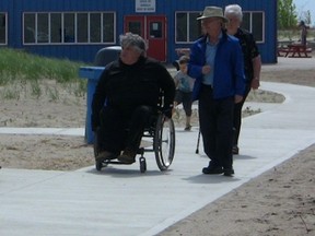 Doug Mayer, left, chair of the Joint Accessibility Advisory Committee, and Central Elgin Mayor David Marr stroll along the new boardwalk at the Port Stanley beach. The boardwalk was given a revamp recently to make it more accessible. (Contributed photo)