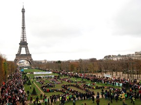 This file photo taken on December 12, 2015 shows Several Non Governmental Organisations (NGO)as they gather to form a human chain reading "+3°C SOS" on the Champs de Mars near the Eiffel Tower in Paris on the sidelines of the COP21, the UN conference on global warming. / AFP PHOTO / ALAIN JOCARDALAIN