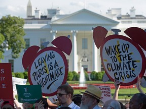 Protesters gather outside the White House in Washington, Thursday, June 1, 2017, to protest President Donald Trump's decision to withdraw the Unites States from the Paris climate change accord. (AP Photo/Susan Walsh)