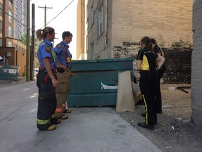 Members of the Winnipeg Fire Paramedic Service and street patrol inspect a backlane dumpster. The Winnipeg Fire Paramedic Service is partnering up with local Biz groups and Take Pride Winnipeg to identify and report properties that are at risk of arson, it was announced on Friday, June 2, 2017. The program is an expansion of the Community Fire Prevention Partnership (CFPP), which has already been running for several years. As a part of this program, BIZ employees will be trained in identifying potential fire hazards, and report them to the city’s 311 contact centre for follow-up by Community By-law Enforcement Services or the WFPS. JASON FRIESEN/Winnipeg Sun/Postmedia Network