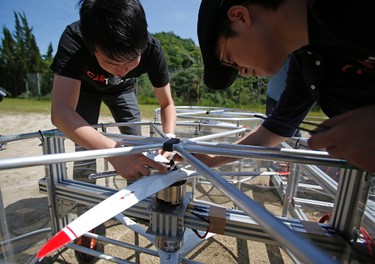 Tsubasa Nakamura, project leader of Cartivator, left, works on the test model flying car in Toyota, central Japan, Saturday, June 3, 2017. (AP Photo/Koji Ueda)