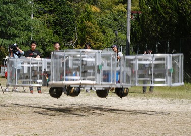 Tsubasa Nakamura, project leader of Cartivator, second from left, watches the flight of the test model of the flying car on a former school ground in Toyota, central Japan, Saturday, June 3, 2017. (AP Photo/Koji Ueda)