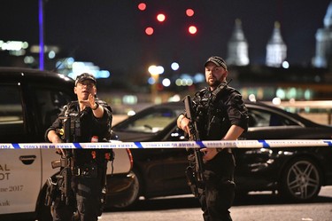 Armed Police officers stand guard on London Bridge in central London, Saturday, June 3, 2017.  British police said they were dealing with "incidents" on London Bridge and nearby Borough Market in the heart of the British capital Saturday, as witnesses reported a vehicle veering off the road and hitting several pedestrians. (Dominic Lipinski/PA via AP)