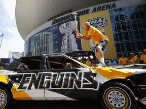 A Nashville Predators fan hits a Pittsburgh Penguins car with a sledgehammer prior to Game 3 of the Stanley Cup Final at the Bridgestone Arena on June 3, 2017 in Nashville. (Patrick Smith/Getty Images)