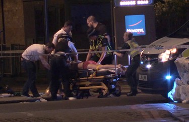 In this image made from PA Video footage, people receive medical attention in Thrale Street near London Bridge following an attack Sunday, June 4, 2017.  (Federica De Caria/PA via AP)