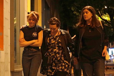 People walk away about 10 minutes after midnight from inside a police cordon after an attack in London, Sunday, June 4, 2017. (AP Photo/Matt Dunham)
