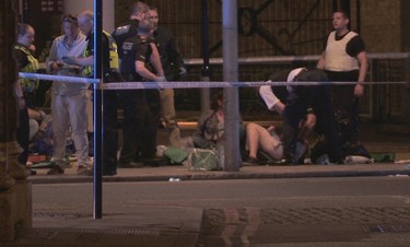 In this image made from PA Video footage, people receive medical attention in Thrale Street near London Bridge following an attack Sunday, June 4, 2017.  (Federica De Caria/PA via AP)