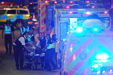 Police officers and members of the emergency services attend to a person injured in an apparent terror attack on London Bridge in central London on June 3, 2017. (DANIEL SORABJI/AFP/Getty Images)