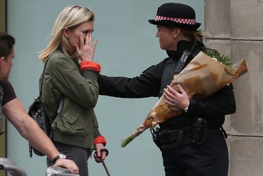 A woman reacts after asking a Police officer to lay flowers near London Bridge in London on June 4, 2017, as a tribute to the victims of the June 3 terror attack. (DANIEL LEAL-OLIVAS/AFP/Getty Images)