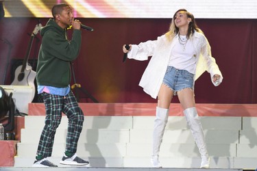 In this Sunday, June 4, 2017, handout photo provided by Dave Hogan for One Love Manchester, singers Pharrell Williams, left, and Miley Cyrus perform at the One Love Manchester tribute concert in Manchester, north western England, Sunday, June 4, 2017.  (Dave Hogan via AP)