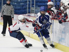 Payton Vescio, left, of the North Bay Trappers, checks Brandon Atkins, of the Sudbury Nickel Capital Wolves, into the boards during midget AAA hockey action at the Great North Midget League championship series at the Sudbury Community Arena in Sudbury, Ont. on Saturday March 11, 2017. Atkins signed with the Rayside-Balfour Canadians on the weekend. John Lappa/Sudbury Star/Postmedia Network