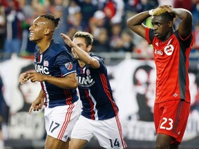 New England Revolution’s Juan Agudelo (left) celebrates his goal with teammate Diego Fagundez as Toronto FC’s Chris Mavinga reacts during the second half of their match Saturday in Foxborough, Mass. The worn-out Reds lost 3-0. (The Associated Press)