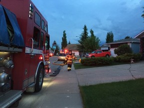 Emergency crews are seen at a house fire at 17808 93 St., Sunday night. (CATHERINE GRIWKOWSKY)