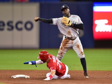 New York Yankees shortstop Didi Gregorius (right) forces out Toronto Blue Jays' Devon Travis at second base and throws to first to complete a double play during fifth inning American League baseball action in Toronto, Sunday, June 4, 2017. THE CANADIAN PRESS/Frank Gunn ORG XMIT: FNG505