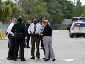 Authorities confer Monday, June 5, 2017, following a shooting in an industrial area near Orlando.  (AP Photo/John Raoux)