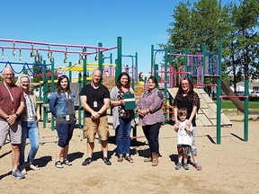 Photo submitted.
Left to right: Curtis Currie, Erin Heward, Marcie Enders, Andrew Craig, Karissa Sparling, MLA Erin Babcock, Cindy Owles and Morgan Owles stand in front of the soon-to-be demolished playground at Forest Green School in Stony Plain.