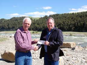 Chuck Lee (left) receives a cheque for $11,385 on behalf of the Alberta Whitewater Association from MLA Pat Stier. The money will go towards purchasing a trailer to support different kayaking events hosted across the province.