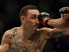 Max Holloway, of the United States, fights Jose Aldo, of Brazil, out of frame at right, during their UFC featherweight mixed martial arts bout in Rio de Janeiro, Brazil, on June 4, 2017. (AP Photo/Leo Correa)