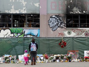 In this Dec. 13, 2016, file photo, flowers, pictures, signs and candles are placed at the scene of a warehouse fire in Oakland, Calif. (AP Photo/Marcio Jose Sanchez, File)