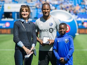 Montreal Impact's Patrice Bernier (centre) receives the Medal of the National Assembly from Quebec Minister of Immigration, Diversity and Inclusiveness Kathleen Weil prior to an MLS soccer game against the Portland Timbers in Montreal on May 20, 2017. (GRAHAM HUGHES/The Canadian Press)