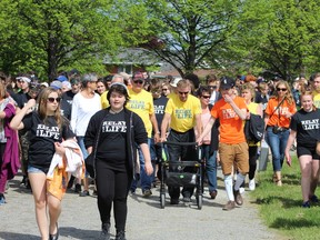 Cancer survivors in yellow shirts walk the Survivor's Lap together with the support of friends, students, teachers and other allies at St. Charles College in Sudbury. Supplied photo