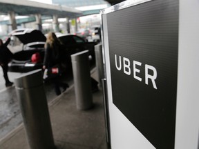 In this March 15, 2017 photo, a sign marks a pick-up point for the Uber car service at LaGuardia Airport in New York. (AP Photo/Seth Wenig)