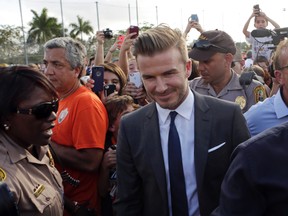 David Beckham, surrounded by Miami-Dade police officers, fans and reporters, arrives at Kendall Soccer Park to visit and greet South Florida soccer fans and players in Miami. (AP Photo/Alan Diaz, File)
