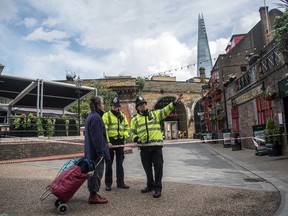 Police officers give directions to a woman near Borough Market on June 6, 2017 in London, England. (Carl Court/Getty Images)