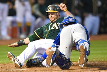 OAKLAND, CA - JUNE 06:  Stephen Vogt #21 of the Oakland Athletics attempting to score from first base on a double by Mark Canha #20 gets tagged out at home plate by Luke Maile #22 of the Toronto Blue Jays in the bottom of the fifth inning at Oakland Alameda Coliseum on June 6, 2017 in Oakland, California.  (Photo by Thearon W. Henderson/Getty Images)