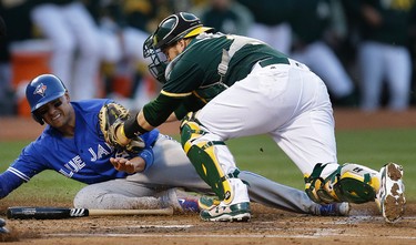 Oakland Athletics catcher Stephen Vogt, right, tags out Toronto Blue Jays' Ryan Goins at home plate in the third inning of a baseball game Tuesday, June 6, 2017, in Oakland, Calif. (AP Photo/Ben Margot) ORG XMIT: OAS106