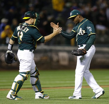 Oakland Athletics' Santiago Casilla, right, and Josh Phegley celebrate the 4-1 win over the Toronto Blue Jays at the end of a baseball game Tuesday, June 6, 2017, in Oakland, Calif. (AP Photo/Ben Margot) ORG XMIT: OAS113